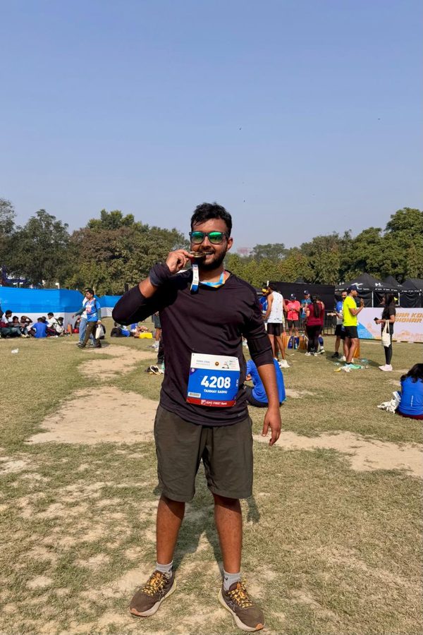 Tanmay biting his finisher medal after a race